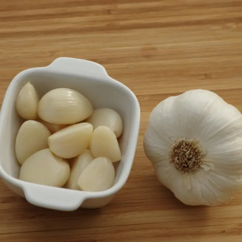 Manfaat Bawang Putih untuk Kesehatan: Si Kecil yang Kaya Khasiat 10 Bawang putih yang sudah dikupas di dalam mangkok dan bawang putih yang belum dikupas.